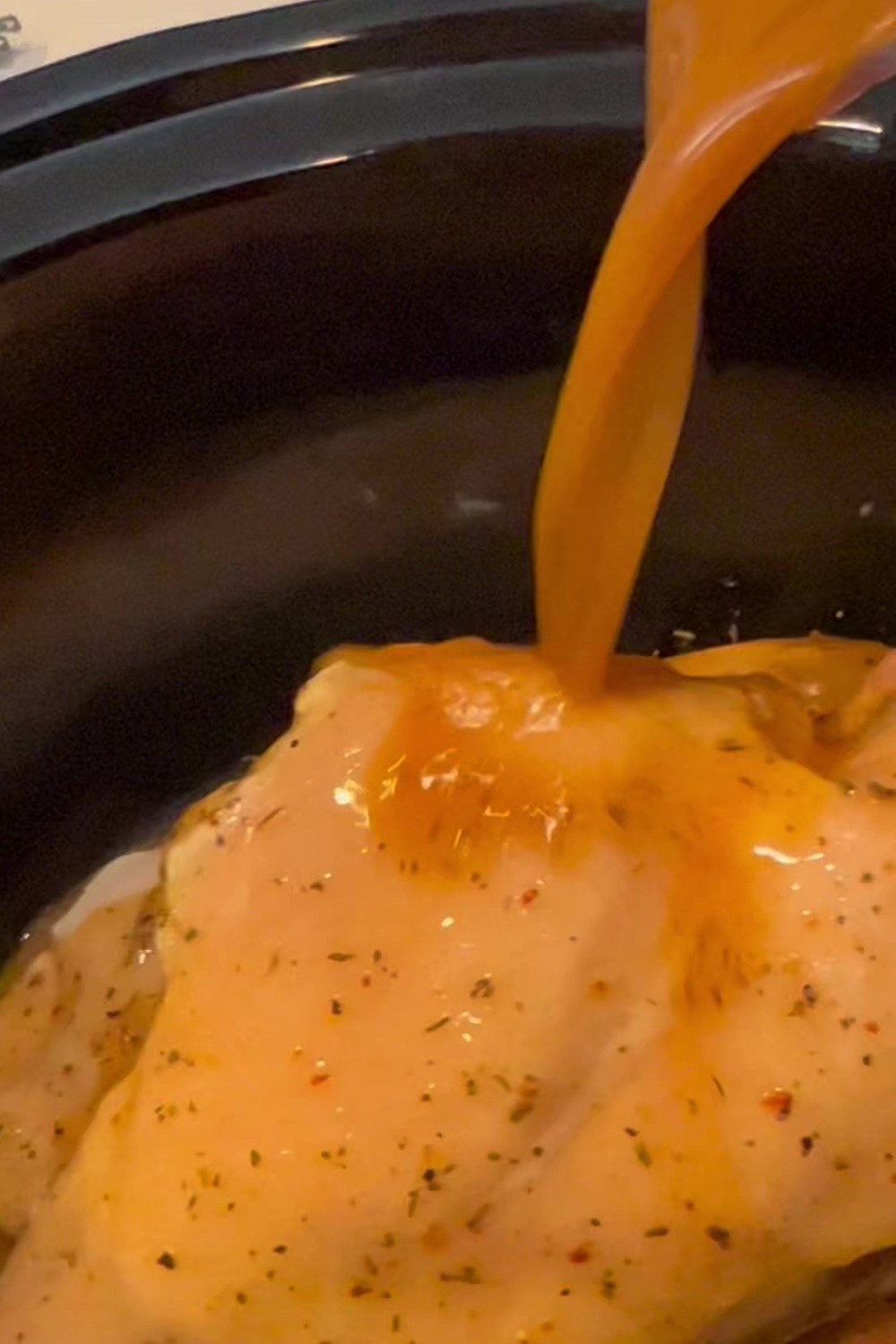 a close up of pouring juice over chicken 