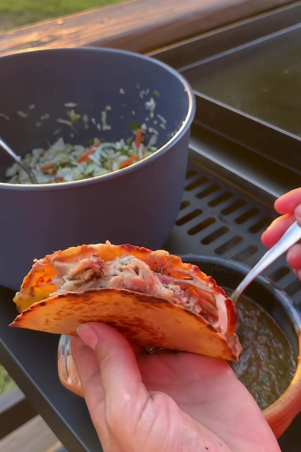 close up of hand holding chicken tacos