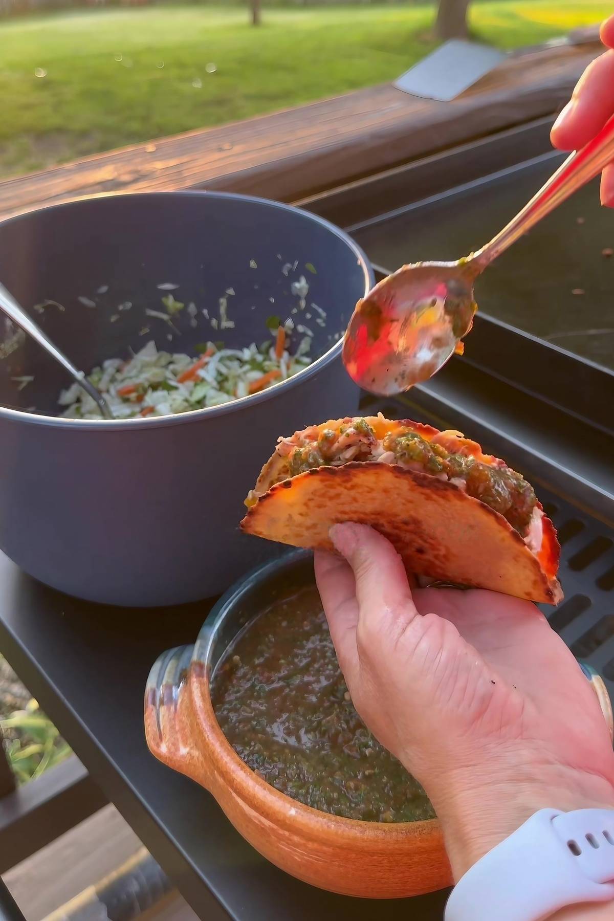 a close up of hand holding chicken mexican tacos